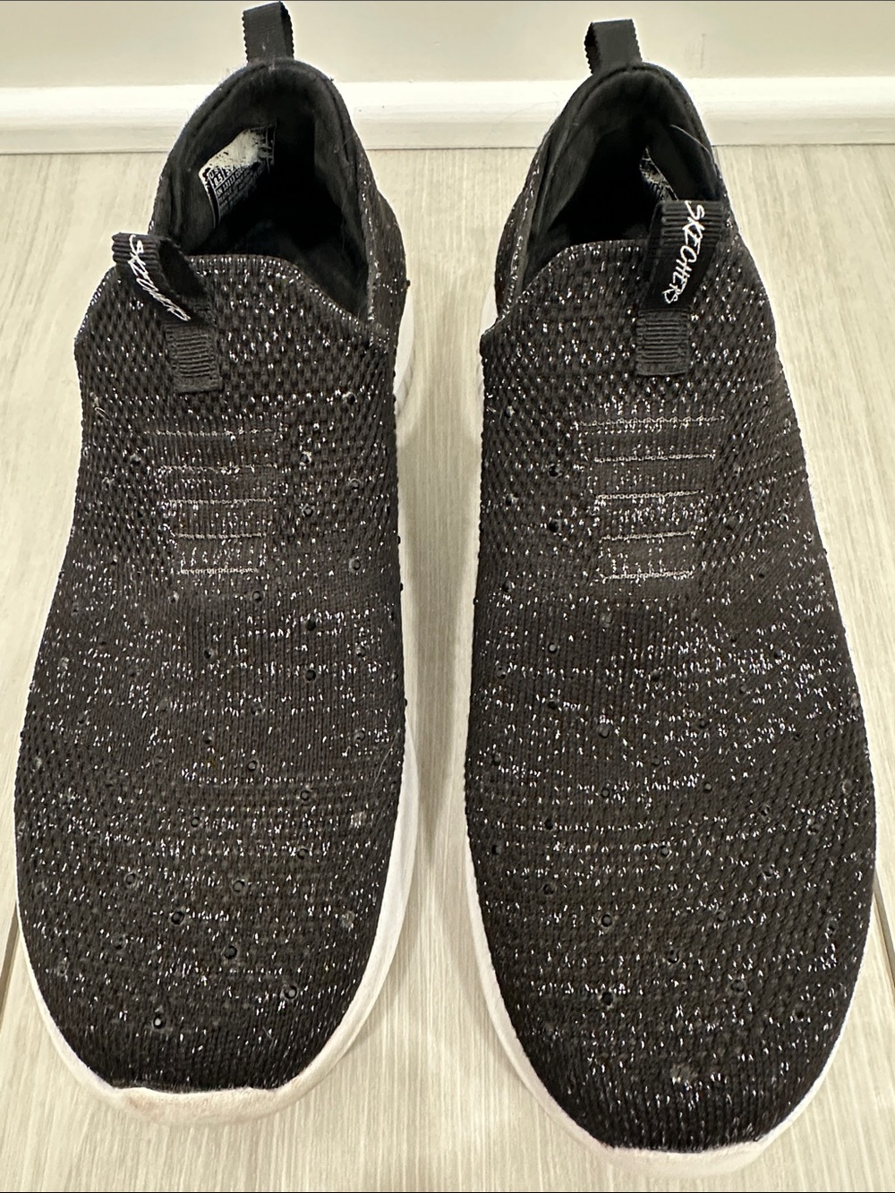 Skechers women’s Black Slip-On Knit Sneakers with White Soles